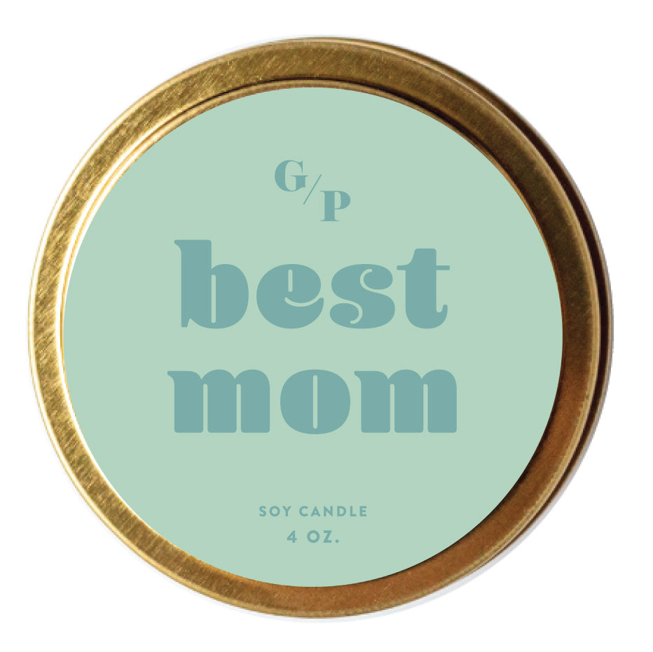 Top view of mint green candle tin lid with 'best mom' text and gold rim.