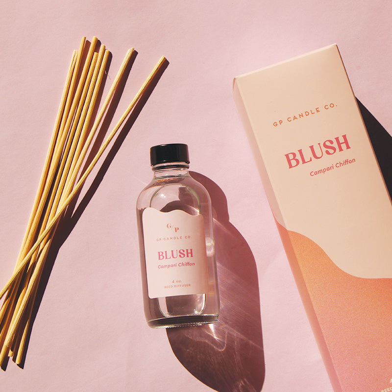 GP Candle Co. 4 oz Blush diffuser with 8 natural reeds and packaging displaying the scent note "Campari Chiffon" on a soft pink background.