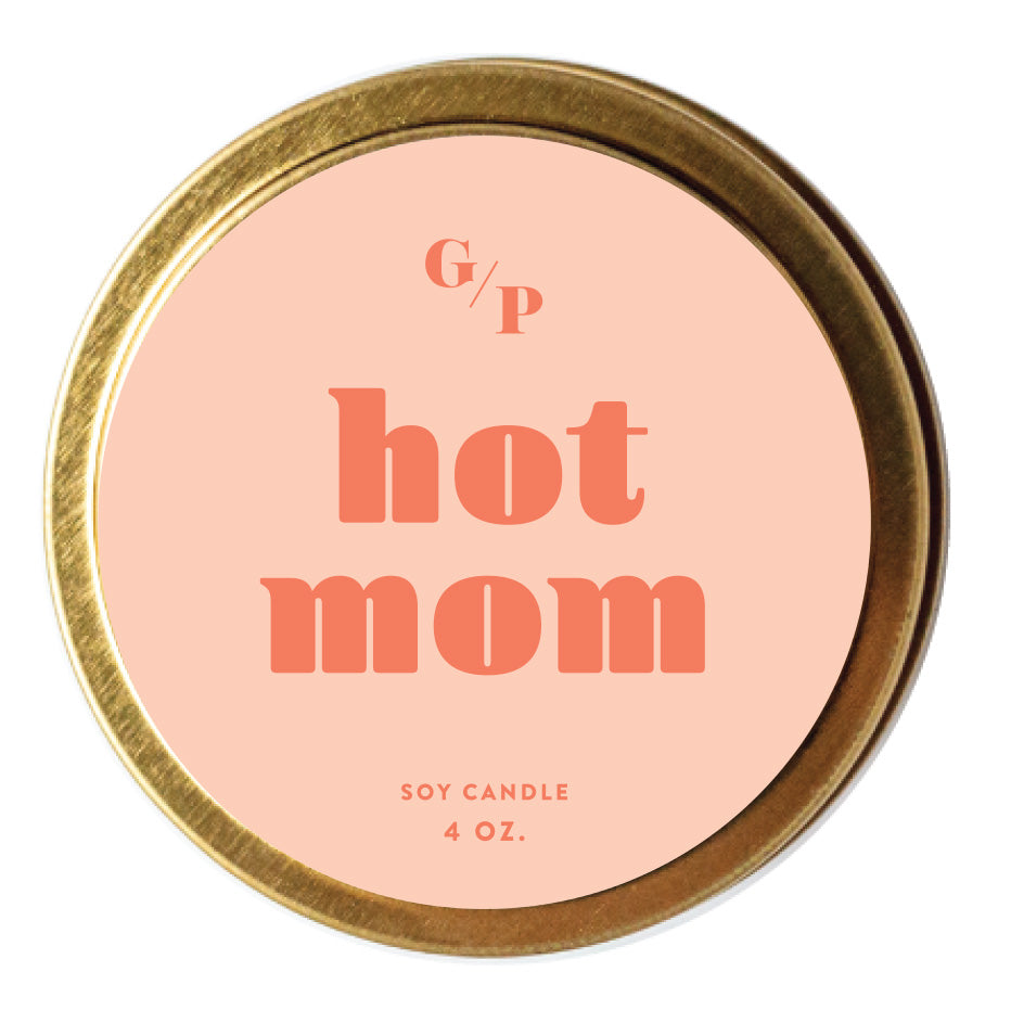 Top view of pink candle tin lid with 'hot mom' text and gold rim.