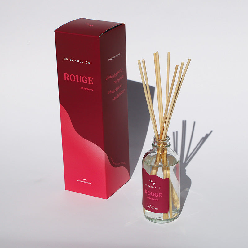 GP Candle Co. Rouge diffuser with packaging on a white background casting shadows in sunlight.