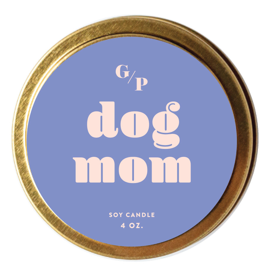 Top view of lilac colored  candle tin lid with 'dog mom' text and gold rim.