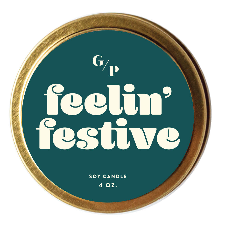 Top view of teal candle tin lid with 'festive af' text and gold rim.