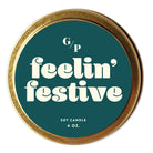 Top view of teal candle tin lid with 'festive af' text and gold rim.