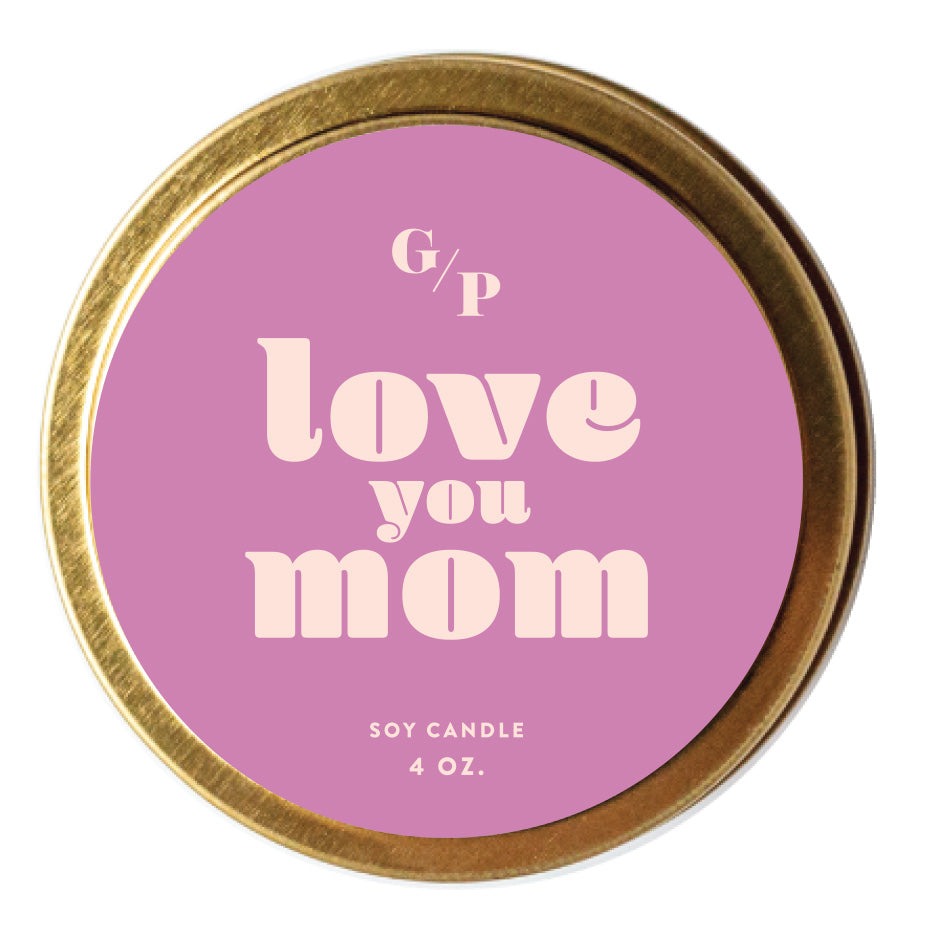 Top view of pink candle tin lid with 'love you mom' text and gold rim.