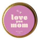 Top view of pink candle tin lid with 'love you mom' text and gold rim.