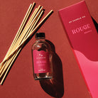 GP Candle Co. 4 oz Rouge diffuser with 8 natural reeds and packaging displaying the scent note "Elderberry" on a red background.