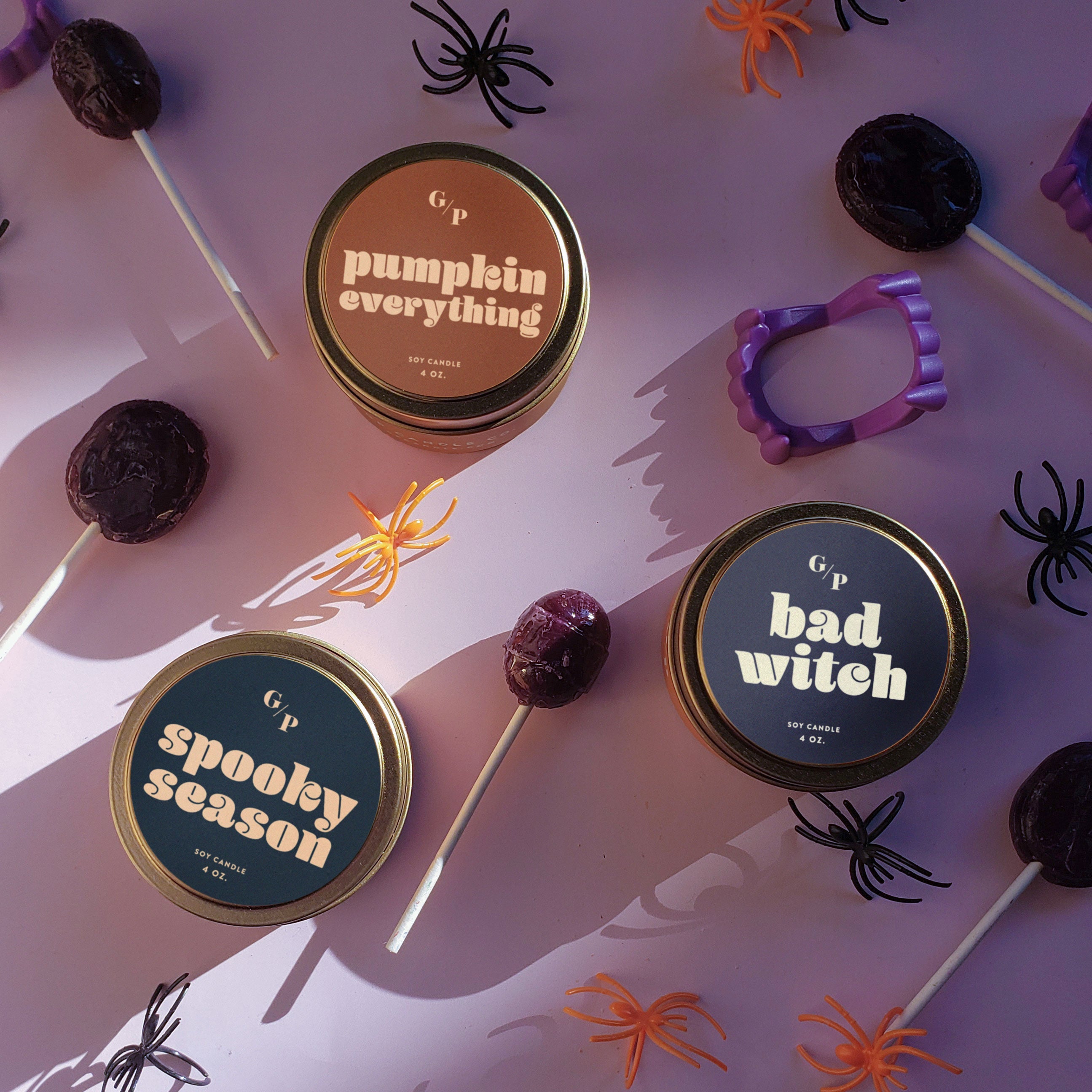 Halloween-themed candles with decorative elements on a purple background